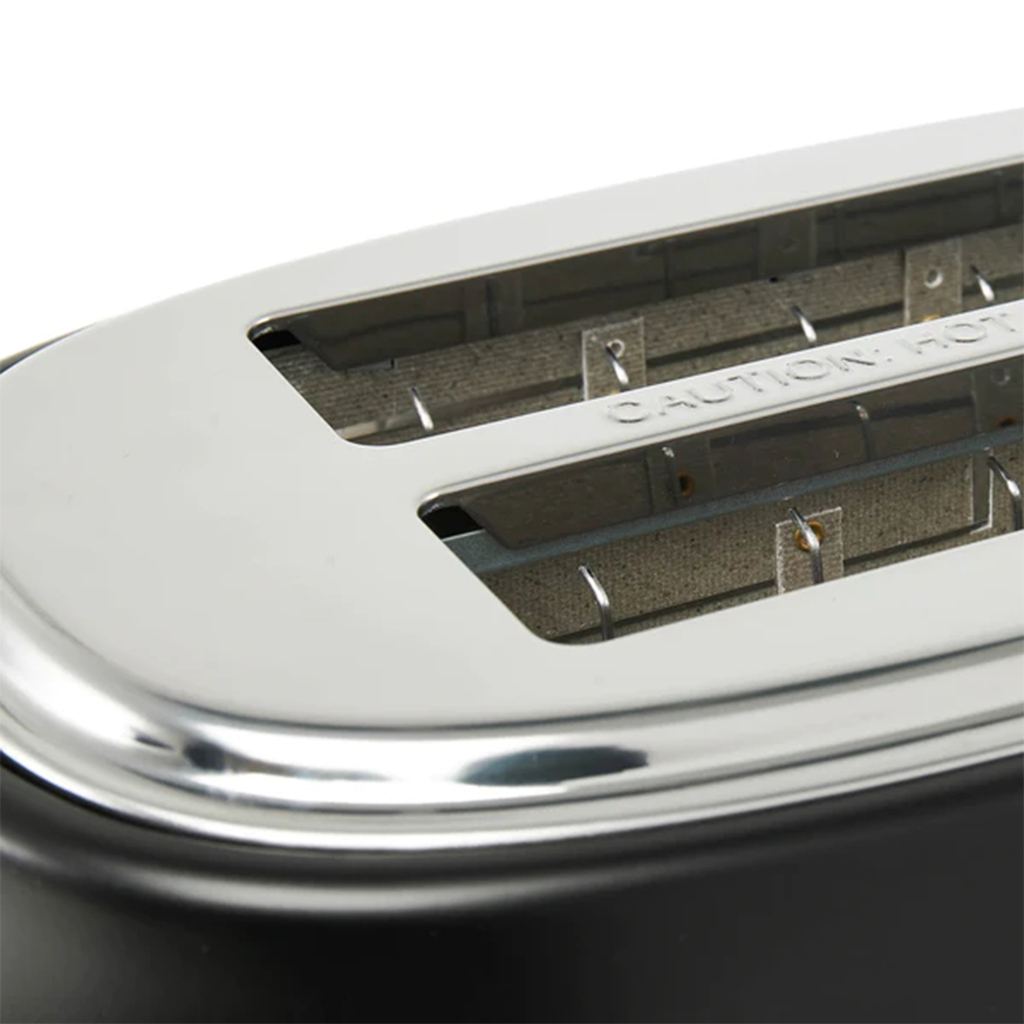 Czarny toster HERITAGE łączy nowoczesne funkcje ze stylizowanym na retro wyglądem. Ma lekko zaokrąglone linie i miedziane wykończenia przycisków i pokręteł.