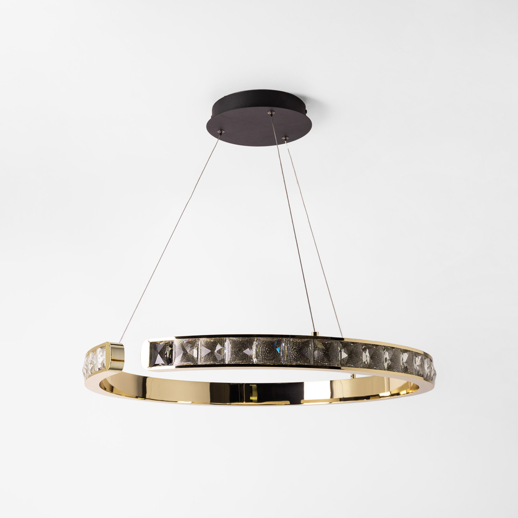 Design MURIEL przypomina złoty pierścień lub obręcz, w której akrylowe kryształki dodają blasku na podobieństwo drogich kamieni.