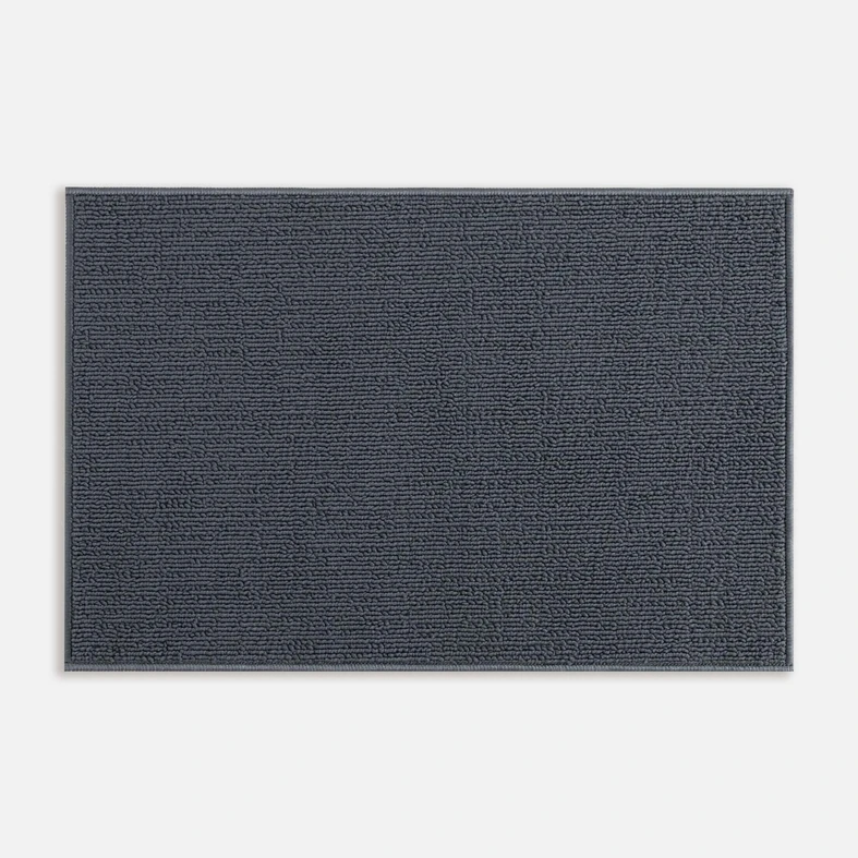 Widok z góry na ciemnoszary dywanik łazienkowy o widocznej pętelkowej strukturze. 