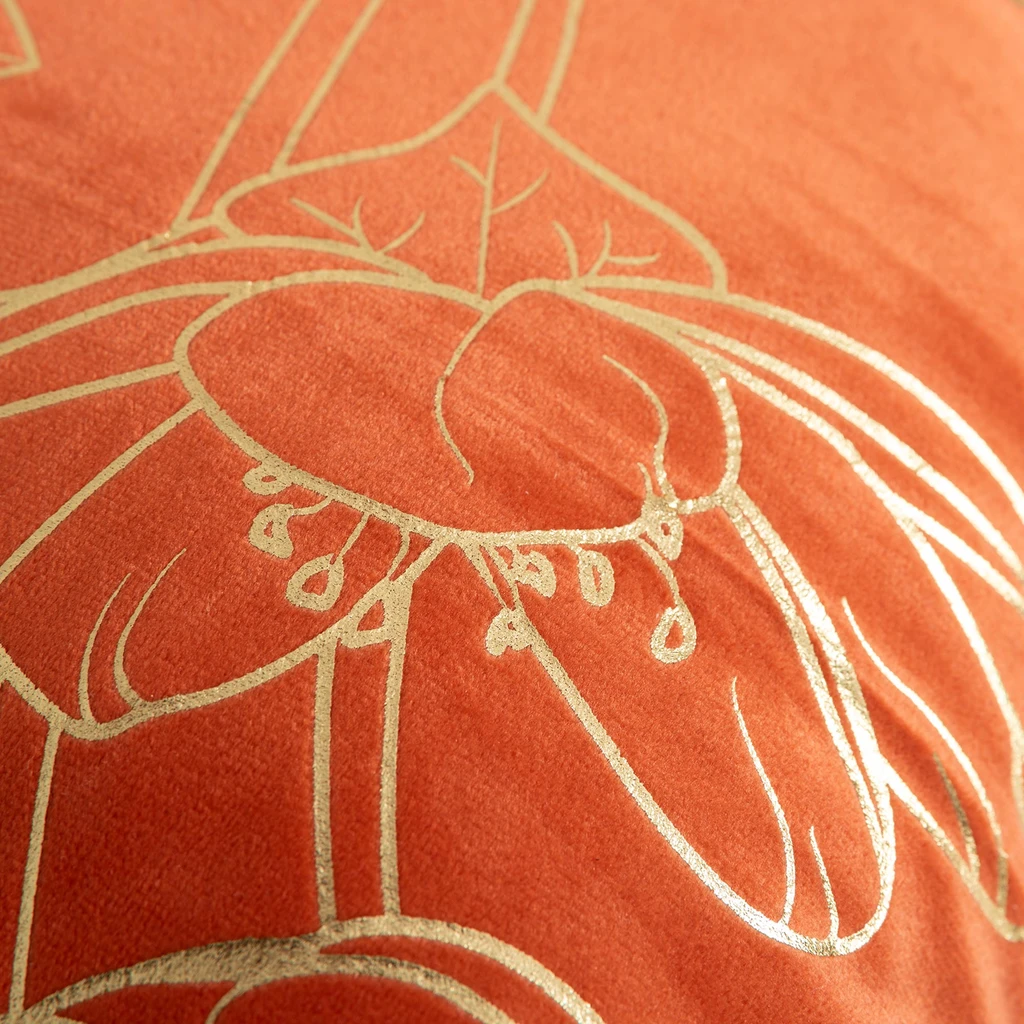 Pomarańczowa poszewka welurowa z roślinnym, kwiatowym wzorem o złotym kolorze