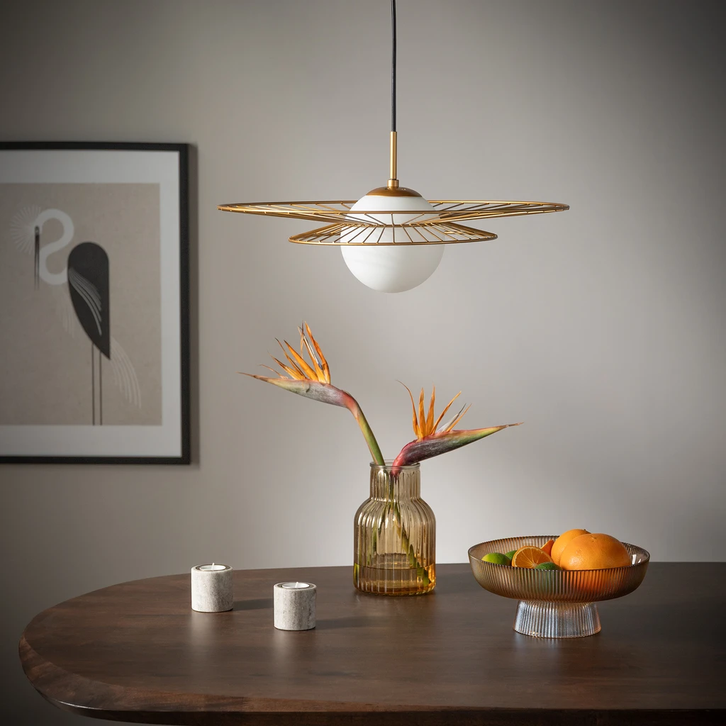 Kulisty klosz lampy ALISON wykonany został ze szkła oraz cienkich metalowych elementów, które tworzą wokół niego półprzeźroczystą konstrukcję.