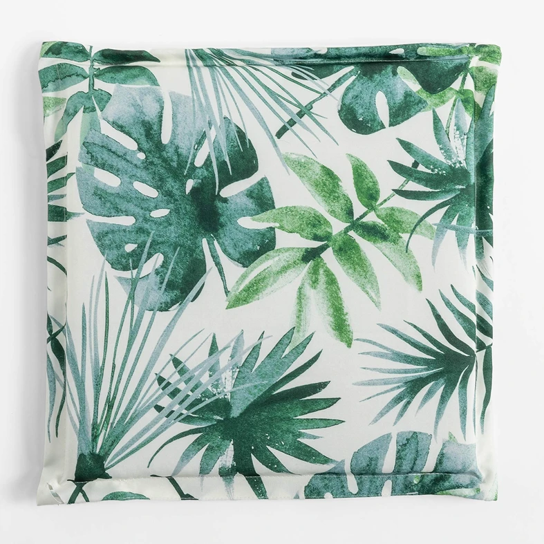 Kwadratowa, płaska poduszka ogrodowa, o wzorze zielonych liści na białym tle, o gładkim, białym tyle.