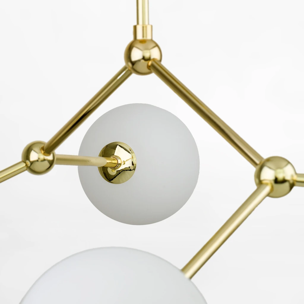 Stelaż w złotym kolorze oraz białe, kuliste klosze rozjaśnią i ocieplą wizualnie wnętrze.