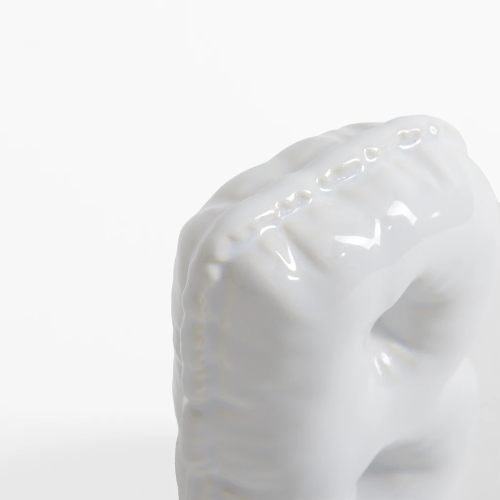 Biała figurka dekoracyjna w kształcie litery B.