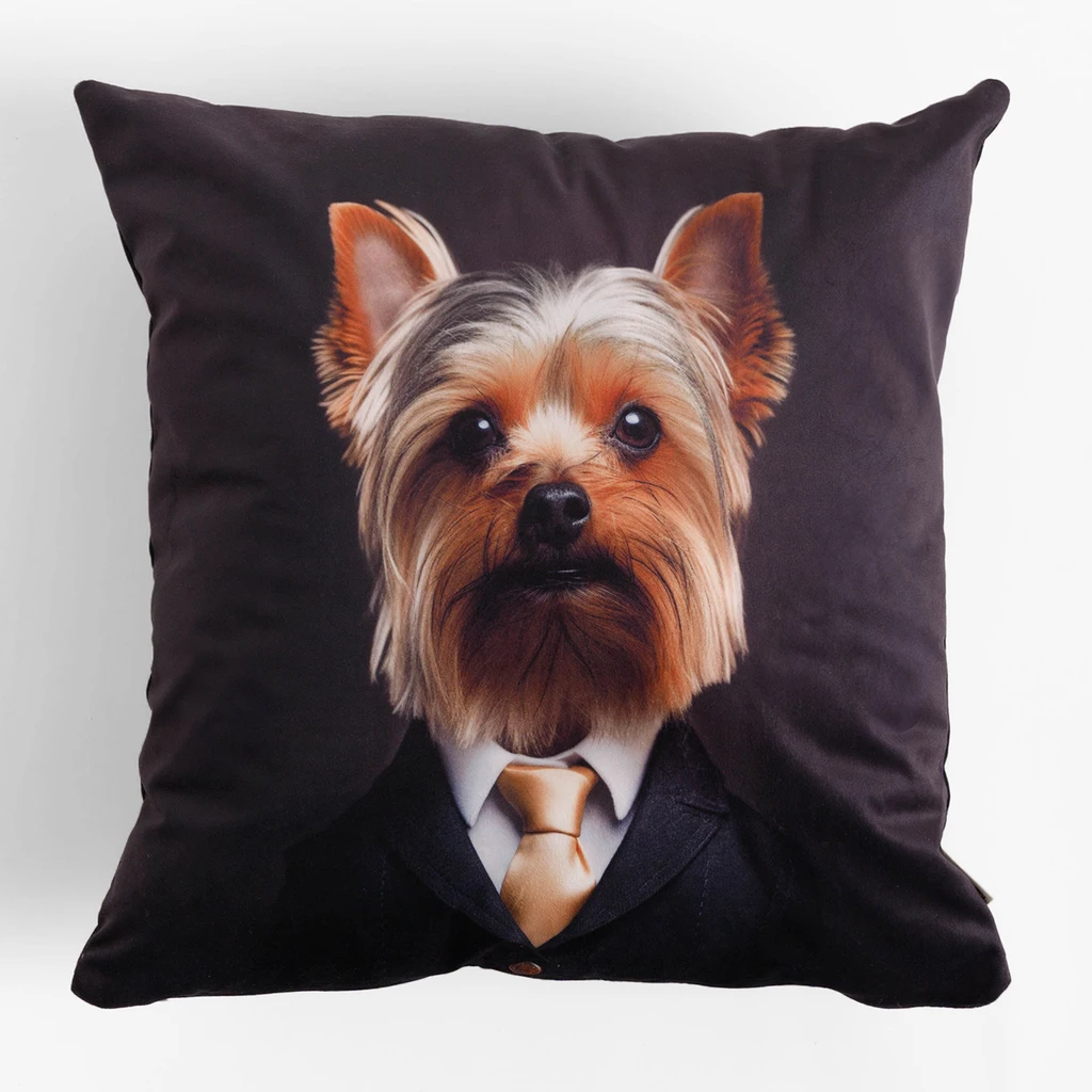 Poduszka z motywem psa w garniturze, z tyłu bez wzoru, w dotyku przypominająca welur, elegancka i nieco surrealistyczna.