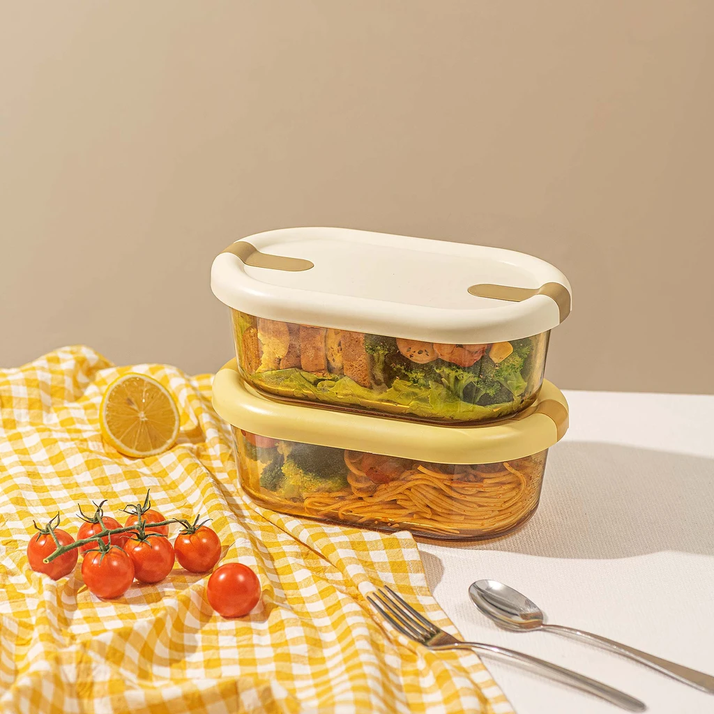 Dwa szklane pojemniki na żywność, jeden na drugim. W jednym makaron z warzywami, w drugim kanapki i krewetki z warzywami.