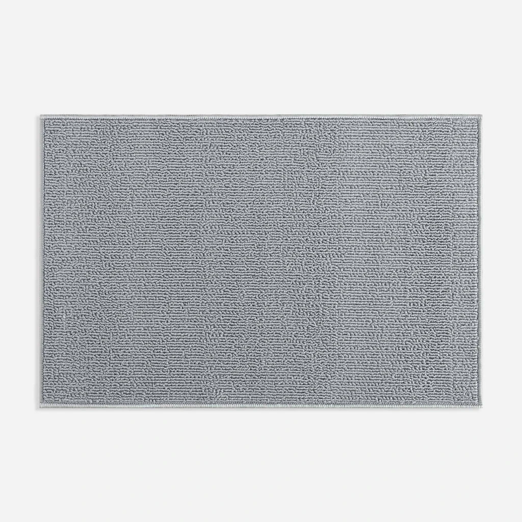 Widok z góry na szary dywanik łazienkowy o widocznej pętelkowej strukturze. 