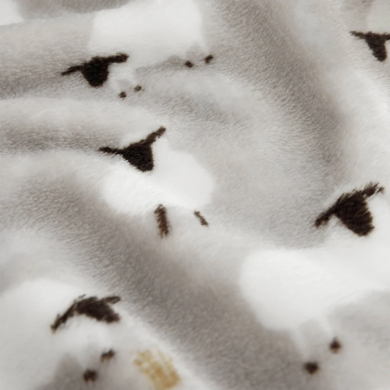 Detal, miękka, puszysta struktura szarego koca, zbliżenie na owieczki.