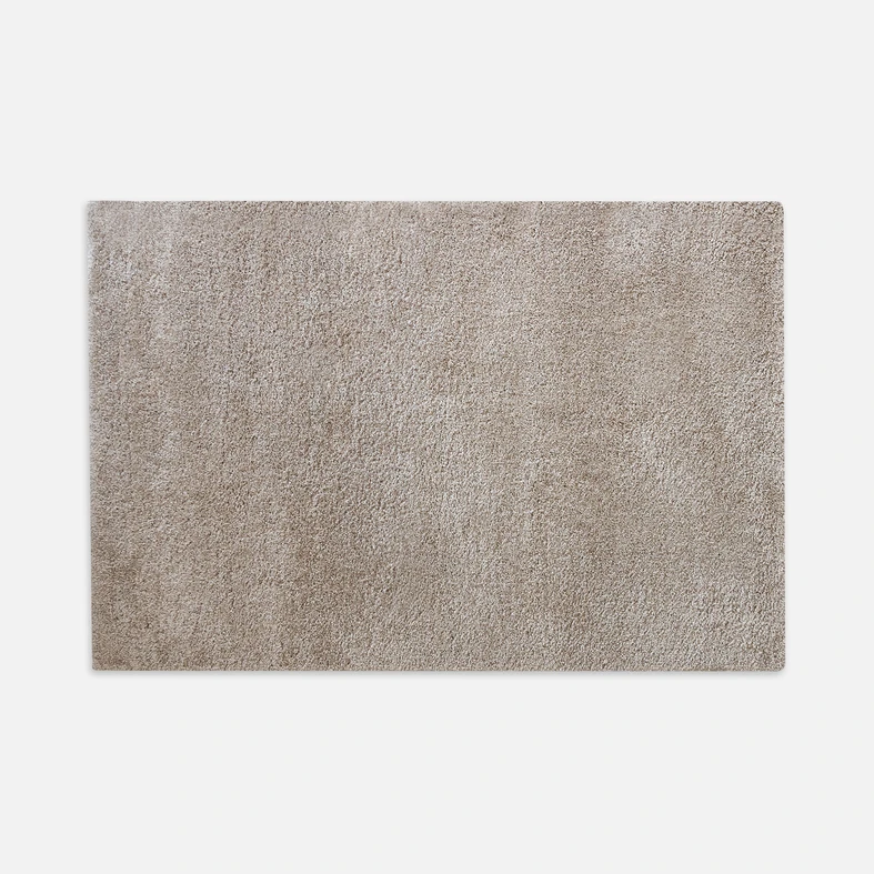 Dywanik beżowy FURRY 50x70 cm wykonany z przędzy polipropylenowej.