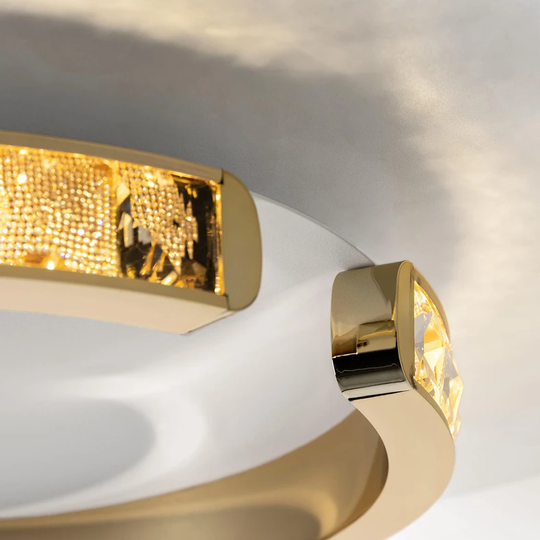 MURIEL to okrągły plafon, którego obramowanie o kształcie zdobionego pierścienia rozjaśni wnętrze ciepłym światłem.