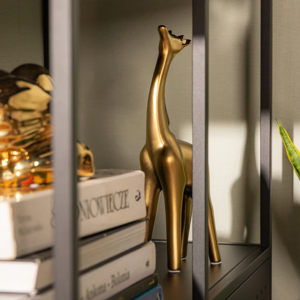 Złota żyrafa z podniesioną do góry szyją.