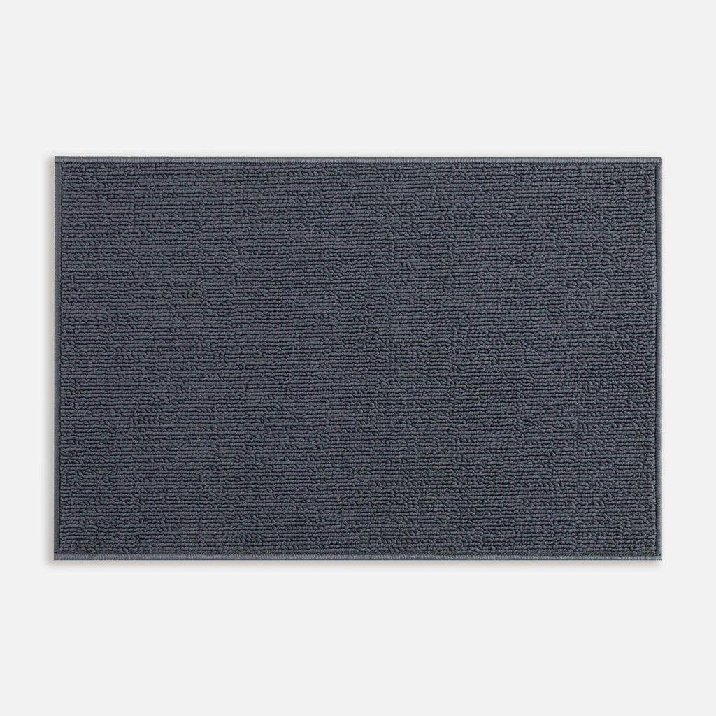 Widok z góry na ciemnoszary dywanik łazienkowy o widocznej pętelkowej strukturze. 