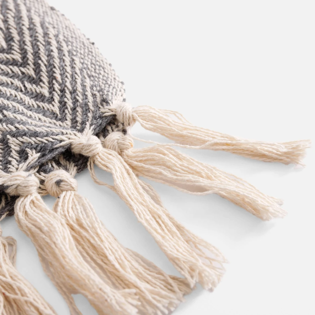 Detal, dekoracyjne, jasnobeżowe frędzle.