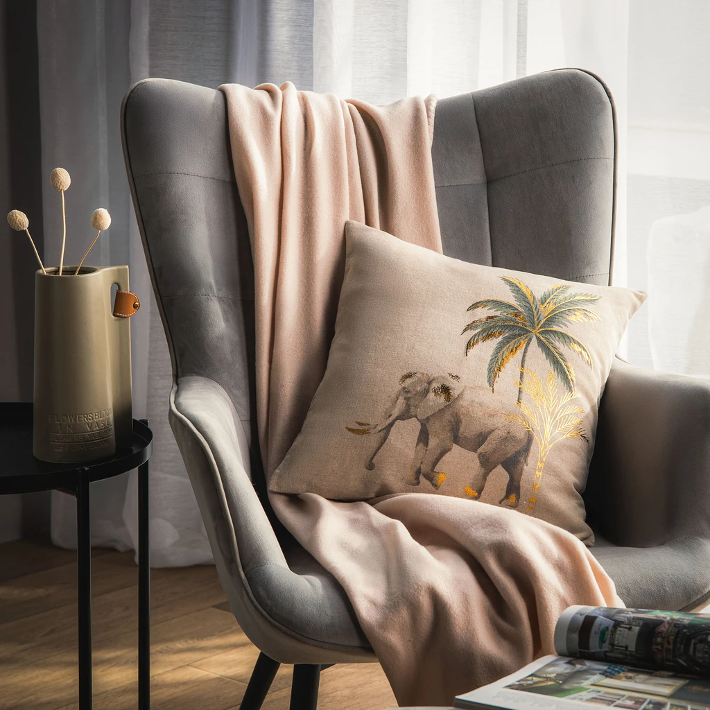 Beżowa poszewka z wędrującym słoniem na tle złotej palmy