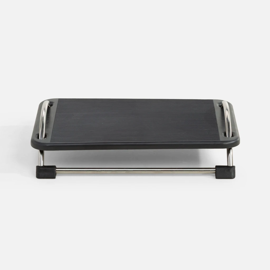 Ujęcie od frontu, podnóżek biurowy z regulacją konta nachylenia o czarnej powierzchni antypoślizgowej i metalowych nóżkach z chromowanym wykończeniem. 