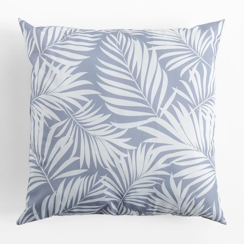 Kwadratowa, puchata poduszka dekoracyjna do ogrodu, o wzorze białych liści palmowych na szarym tle, o gładkim, szarym tyle.