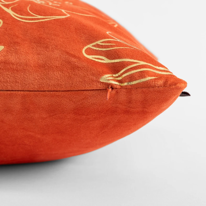Pomarańczowa poszewka welurowa z roślinnym, kwiatowym wzorem o złotym kolorze