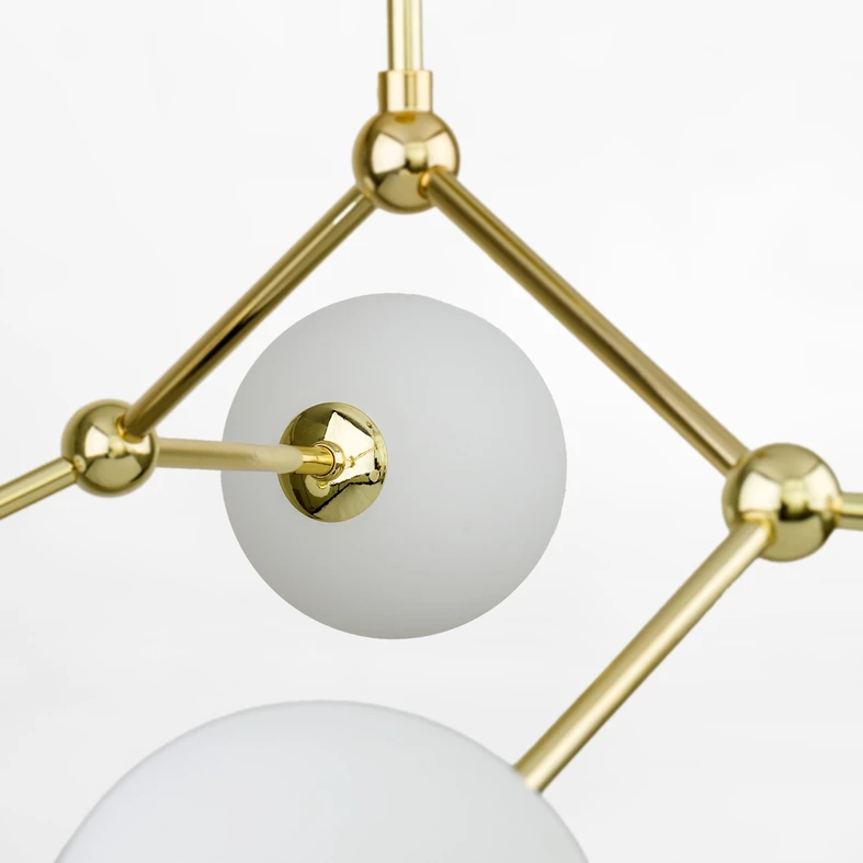 Stelaż w złotym kolorze oraz białe, kuliste klosze rozjaśnią i ocieplą wizualnie wnętrze.