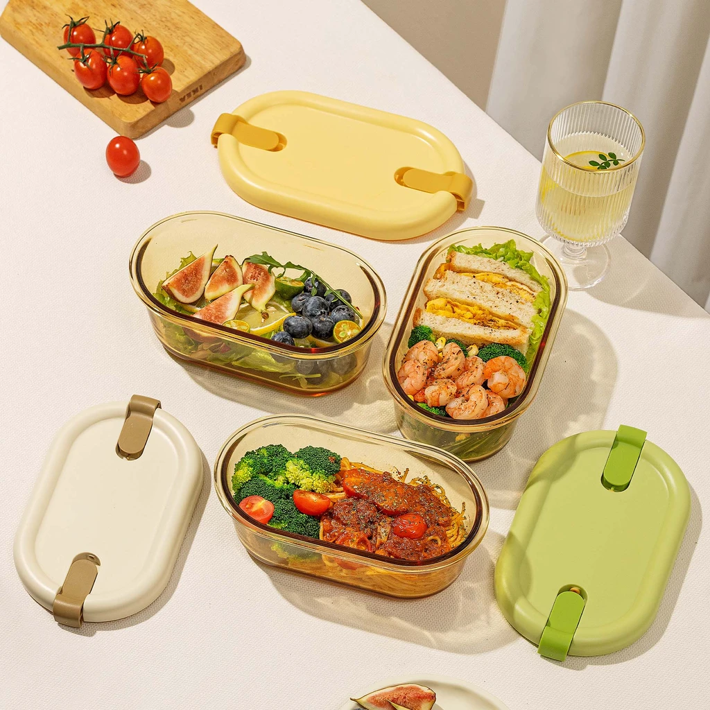 Trzy owalne lunchboxy, w jednym sałatka z figami, w drugim kanapki i krewetki, w trzecim makaron z sosem. 