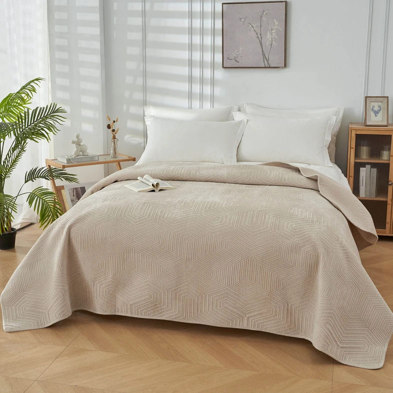 Kremowa narzuta na łóżko o geometrycznym motywie