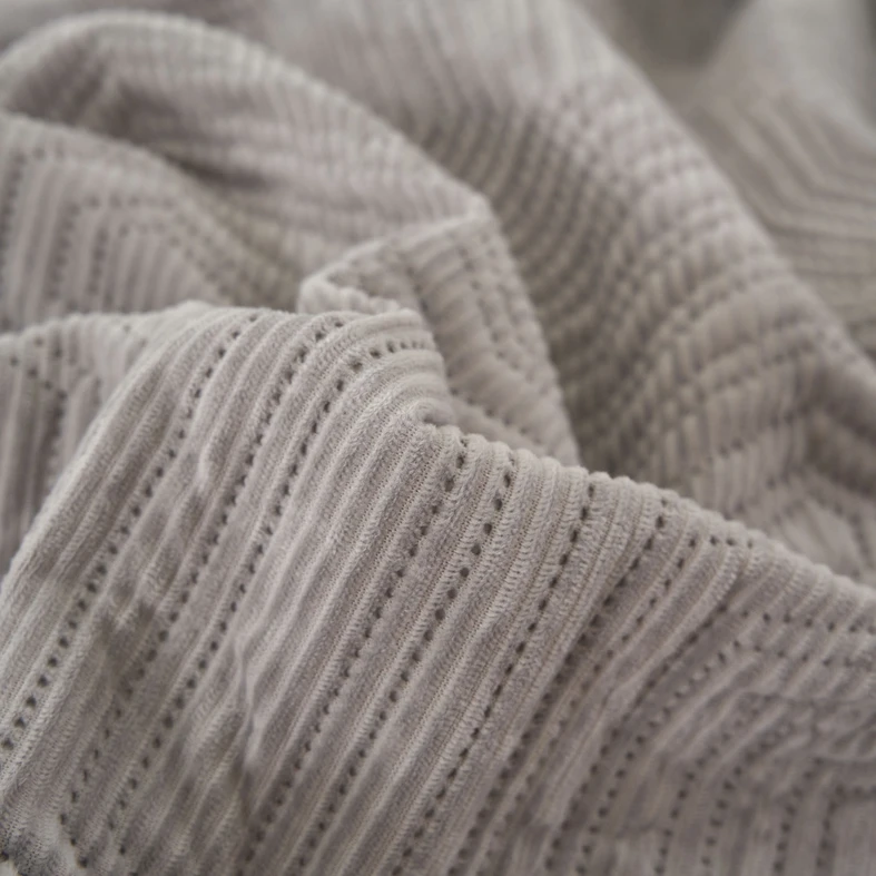 Szara narzuta na łóżko o geometrycznym motywie