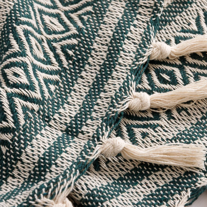 Detal, kremowe frędzle ułożone na tle splotu.