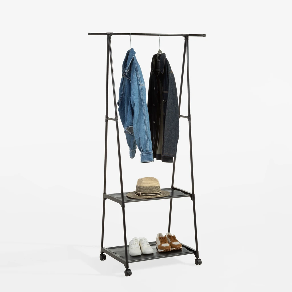 Na drążku na wieszakach jeansowe kurtki, na półkach kapelusz i sportowe buty. Widok z ukosa.