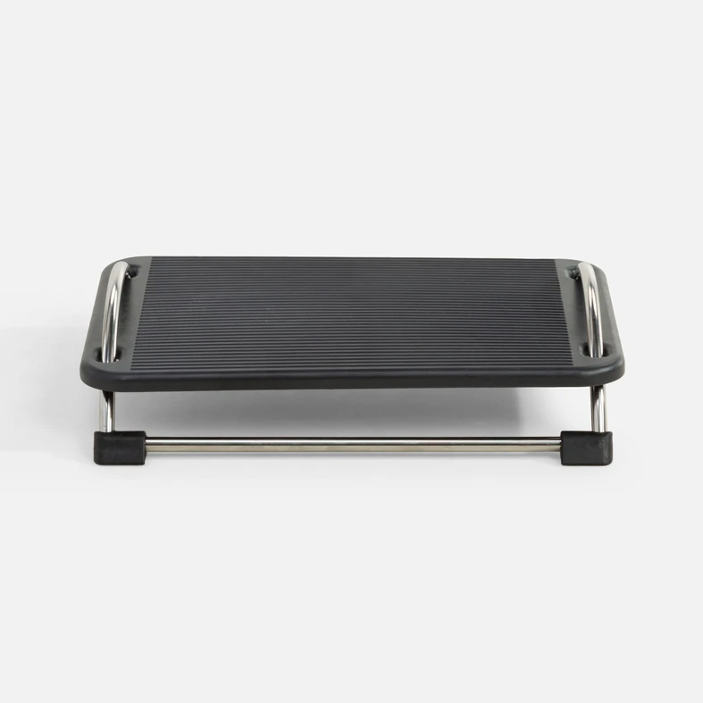 Ujęcie od frontu, podnóżek biurowy z regulacją konta nachylenia o czarnej powierzchni antypoślizgowej i metalowych nóżkach z chromowanym wykończeniem. 