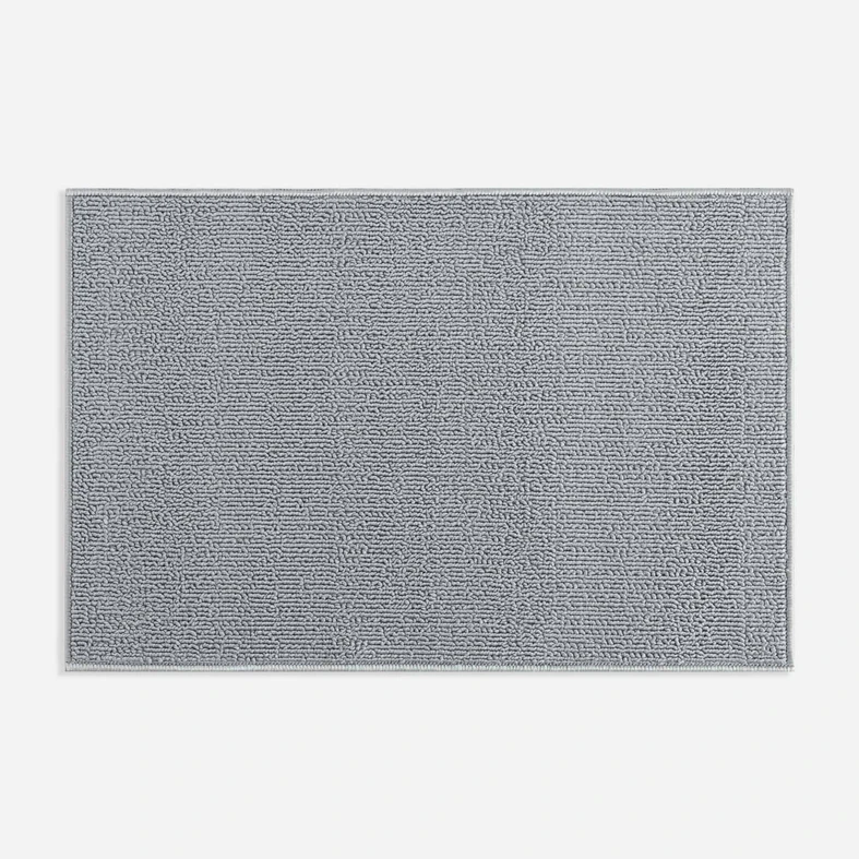 Widok z góry na szary dywanik łazienkowy o widocznej pętelkowej strukturze. 