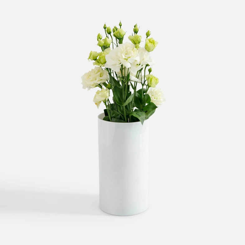 Aranżacja, kwiaty eustomy w kolorze ecru i jasnej zieleni w białym wazonie Luca. 