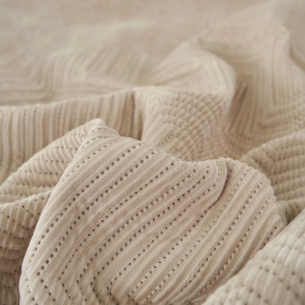 Kremowa narzuta na łóżko o geometrycznym motywie