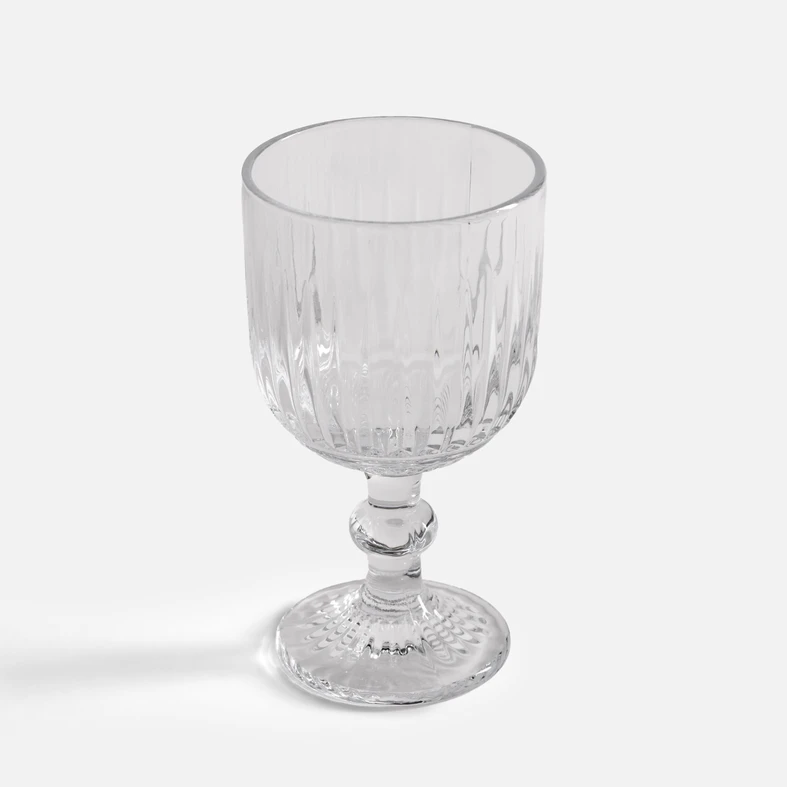 Elegancki kieliszek o pionowych żłobieniach, na dekoracyjnej nóżce.