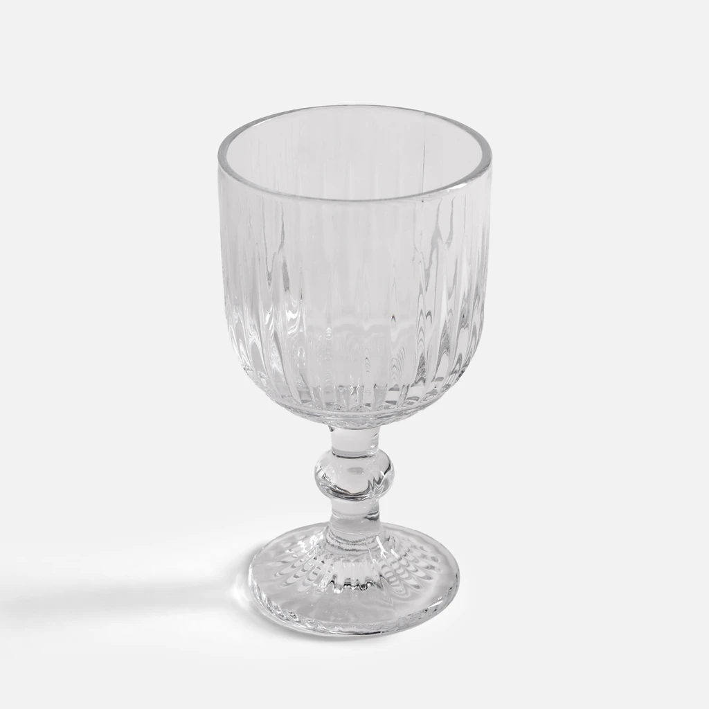Elegancki kieliszek o pionowych żłobieniach, na dekoracyjnej nóżce.