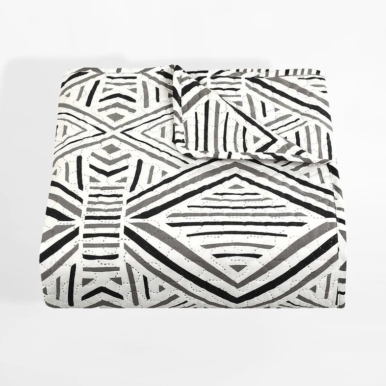 Narzuta na łóżko z czarno -białym wzorem etno